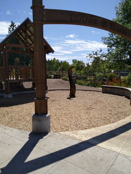 Giant wooden tentacle about two meters tall coming out from wood chips at a playground