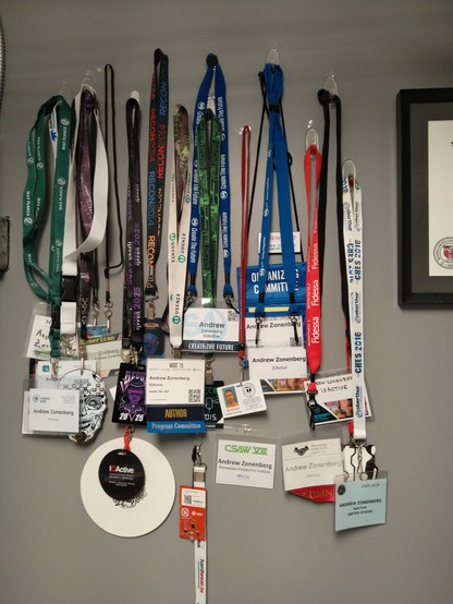 Collection of conference and event badges including REcon 2014, DEF CON 23, CHES 2016, 25th USENIX security symposium, S4x16, HARRIS 2025, CSAW VIII