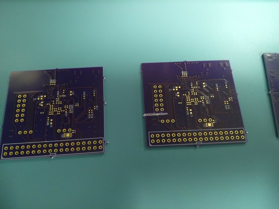 Three purple PCBs one with damage on the edge. Looks like a fiber pulled out or something
