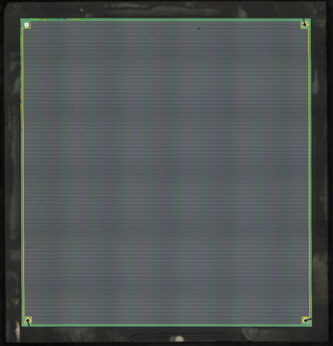 Low resolution overview of a square IC die full of many tiny square features, with one bond pad at each corner. The pad in the northwest is unbonded.