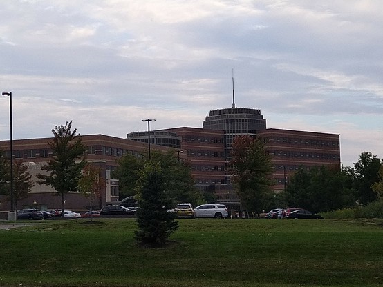 A brown brick building seen from across a parking lot