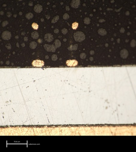 Cross section through a packaged IC showing two copper ball bonds above three aluminum metal layers
