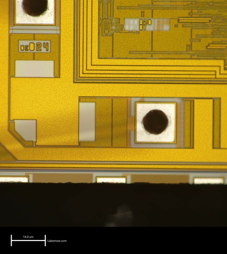 High magnification view of the bottom left corner of the die showing pristine surface and two bond pads