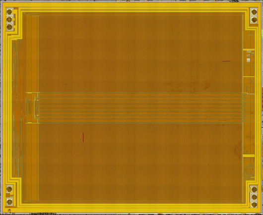 Top metal view of an orange-tinted IC die consisting almost entirely of two big memory arrays north and south of a center addressing block