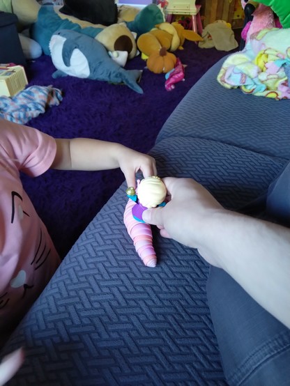 Disney Princess Elsa toy riding on top of a plastic slug held by a young girl