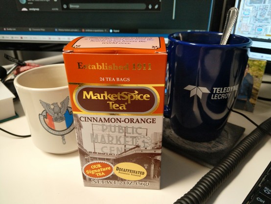 Market Spice Tea cinnamon-orange tea box next to a Teledyne LeCroy drink mug
