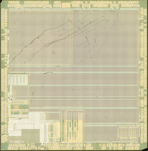 Top metal of an IC die with two rings of bond pads, aluminum top layer power/ground grid, and some analog stuff in the southwest