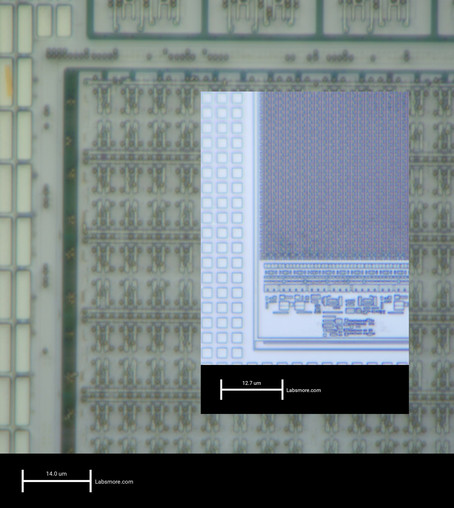 Microscope view of 350nm SRAM bitcells, with all of the contacts and polysilicon details clearly visible.

Inset over the main image is a view of a 90nm SRAM at the same magnification. The bitcells are visible as fuzzy blobs but are so small you can't see any structure.
