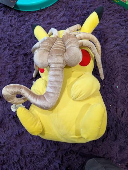 Plush Pikachu with xenomorph facehugger attached to it